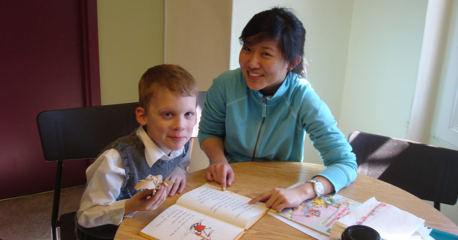 A student tutoring a child at an afterschool club